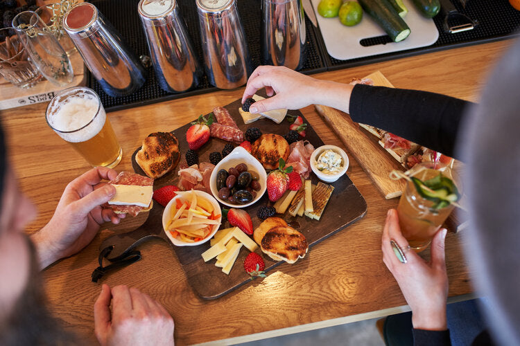 Table top with people sharing food and drinks.